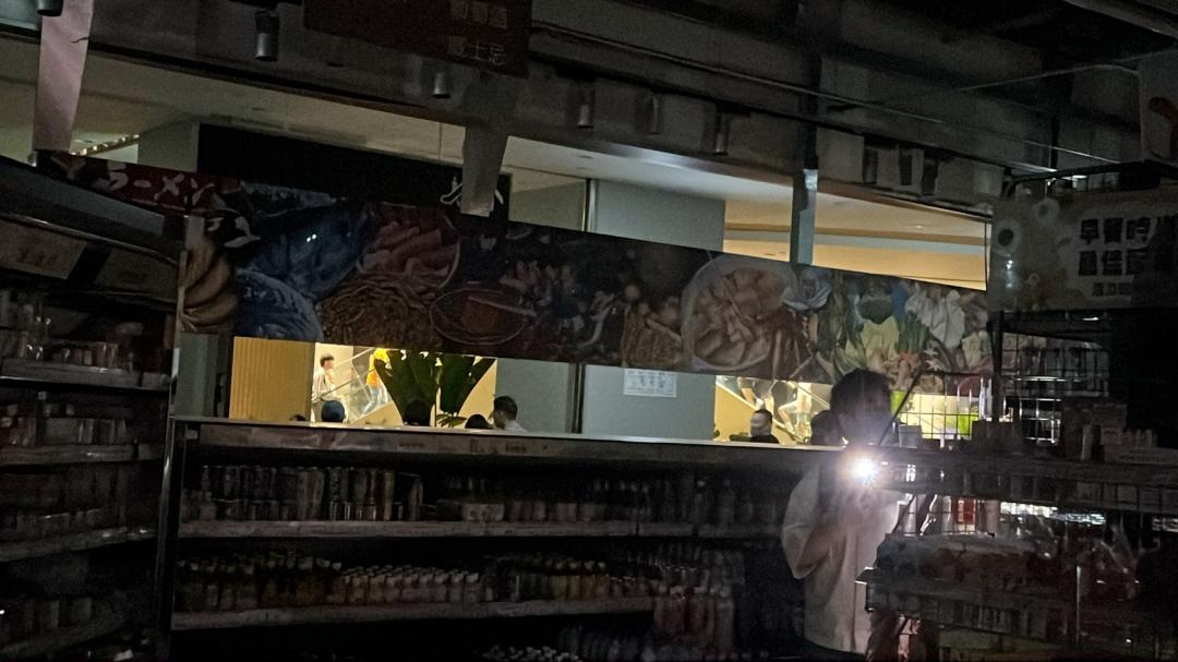 民眾只能靠著手機手電筒的電力照明。（記者劉雅嫺攝）