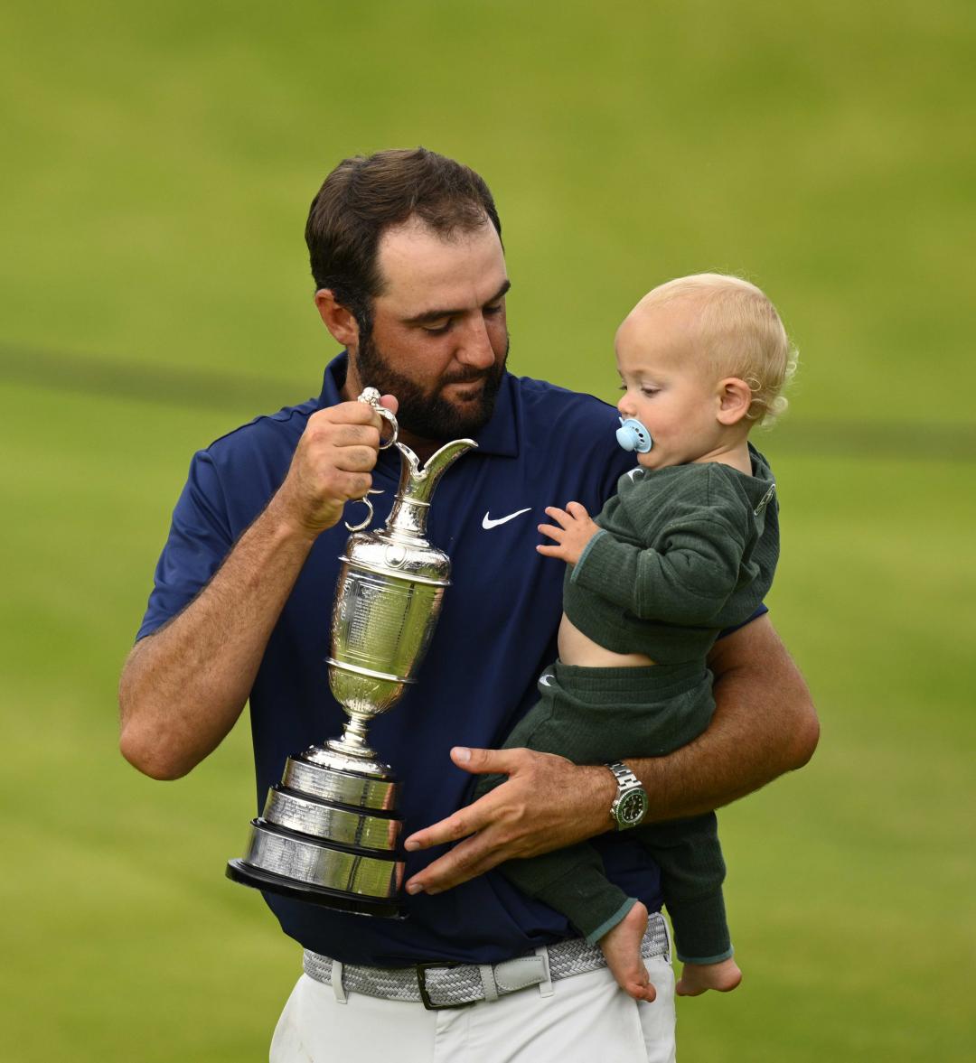 舍夫勒一手捧獎盃、一手抱著兒子，勞力士腕錶成焦點。(歐新社)