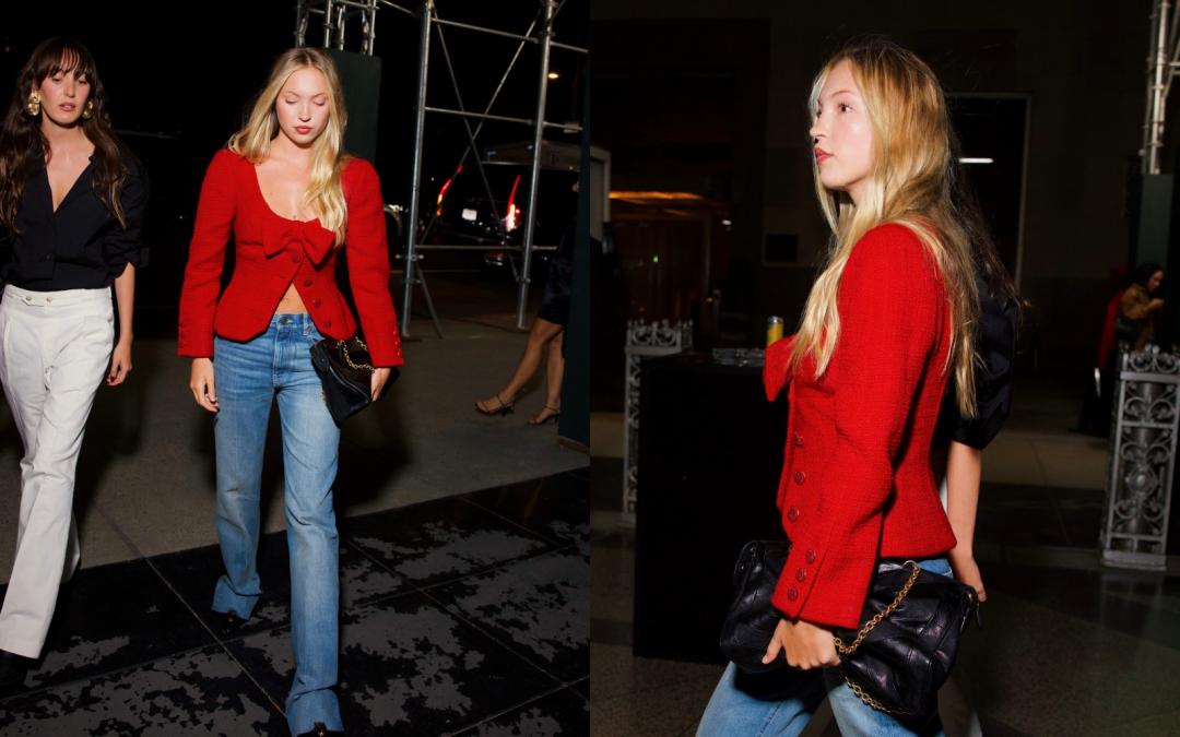 超模凱特摩斯（Kate Moss）女兒Lila Moss，以紅色深U領蝴蝶結外套搭配牛仔褲，勾勒青春叛逆氣息。