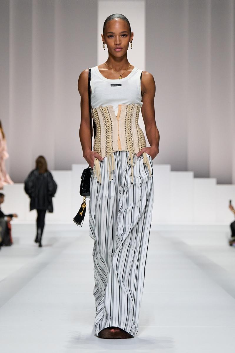 白色坦克背心與直條紋寬褲為基礎，Dolce & Gabbana再以束腰馬甲強化權力性感氛圍。