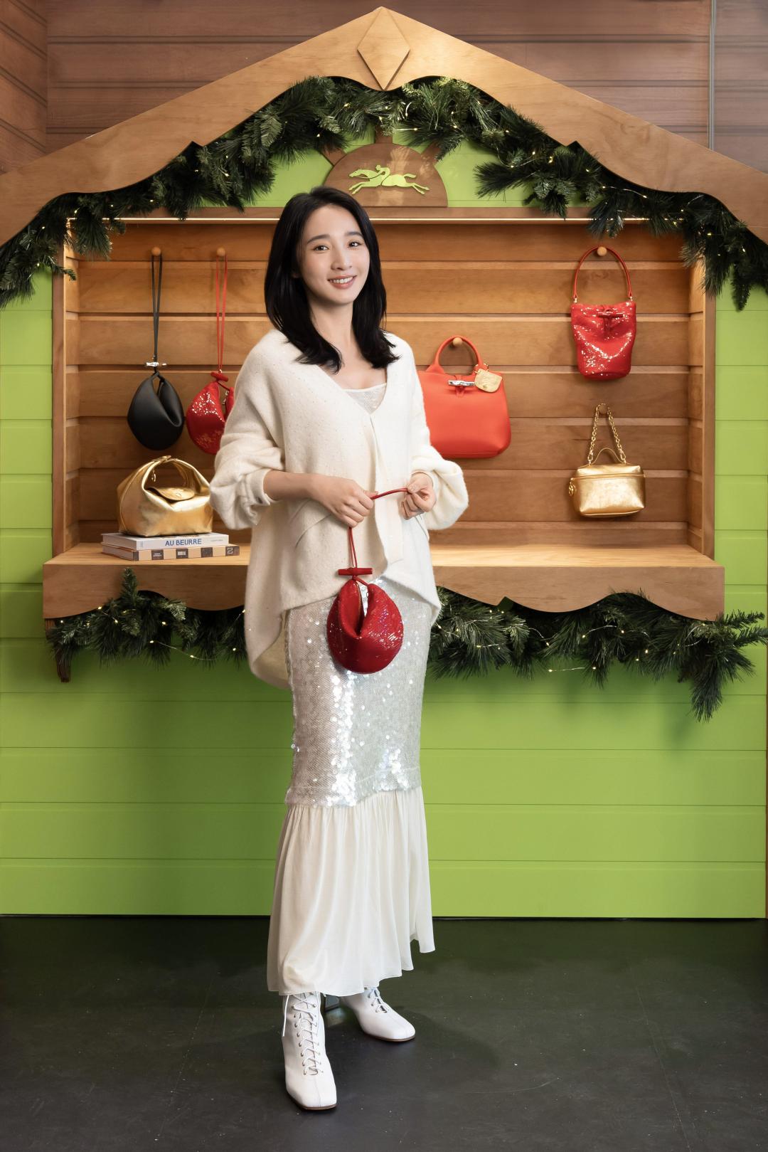 李沐著亮片連身裙（NT$29,600）搭配開襟衫（NT$26,900）勾勒雪國派對風格，並用形似幸運餅乾的Le Roseau系列手拿包（NT$9,900）展現俏皮趣味；足上則是以滑冰鞋為靈感設計的高跟短靴（NT$33,200）。