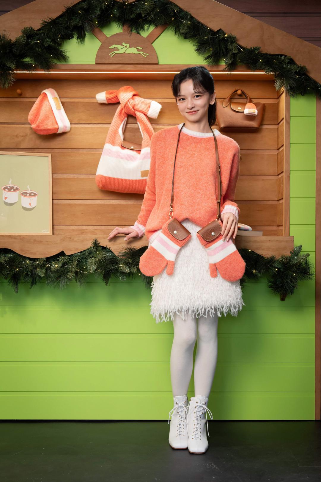 陳姸霏著珊瑚色毛衣（NT$13,100）搭配短裙（NT$20,300）營造俏皮活潑感，脖子上掛著以手套為靈感設計的Le Pliage Cocooning系列斜背包（NT$15,800）；足上則是以滑冰鞋為靈感設計的高跟短靴（NT$33,200）。
