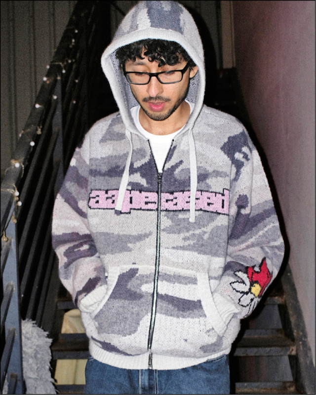 灰白迷彩連帽針織帽衫透過柔軟面料呈現復古街頭輪廓，8,189元。