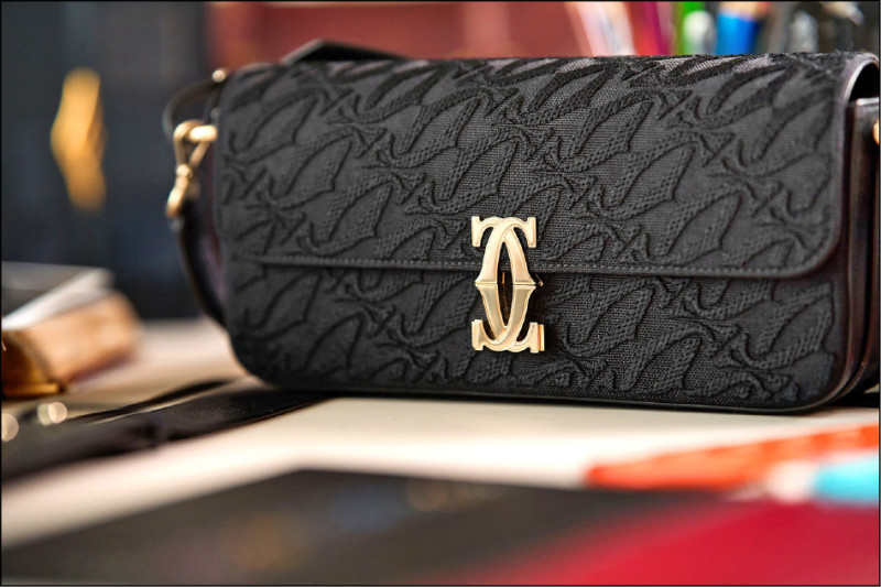 卡地亞C de Cartier系列雙C標誌由皮件與珠寶工作坊共同打造，擁有高辨識度。C de Cartier系列迷你款手提包，黑色小牛皮飾有刺繡，搭配金色鍍層飾面搭扣，103,000元。