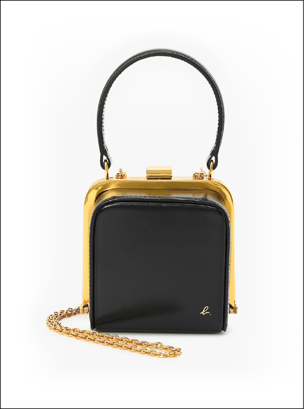 復古牛皮鍊帶包以立體方形結構成為派對造型亮點，26,580元。