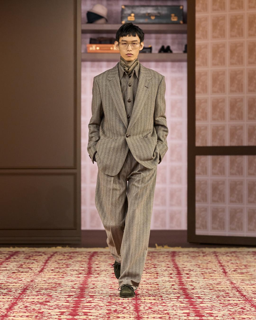 採用鬆弛剪裁重新詮釋正裝比例，細緻直條紋西裝搭配高領內搭，呈現低調卻精準的義式紳士風格。