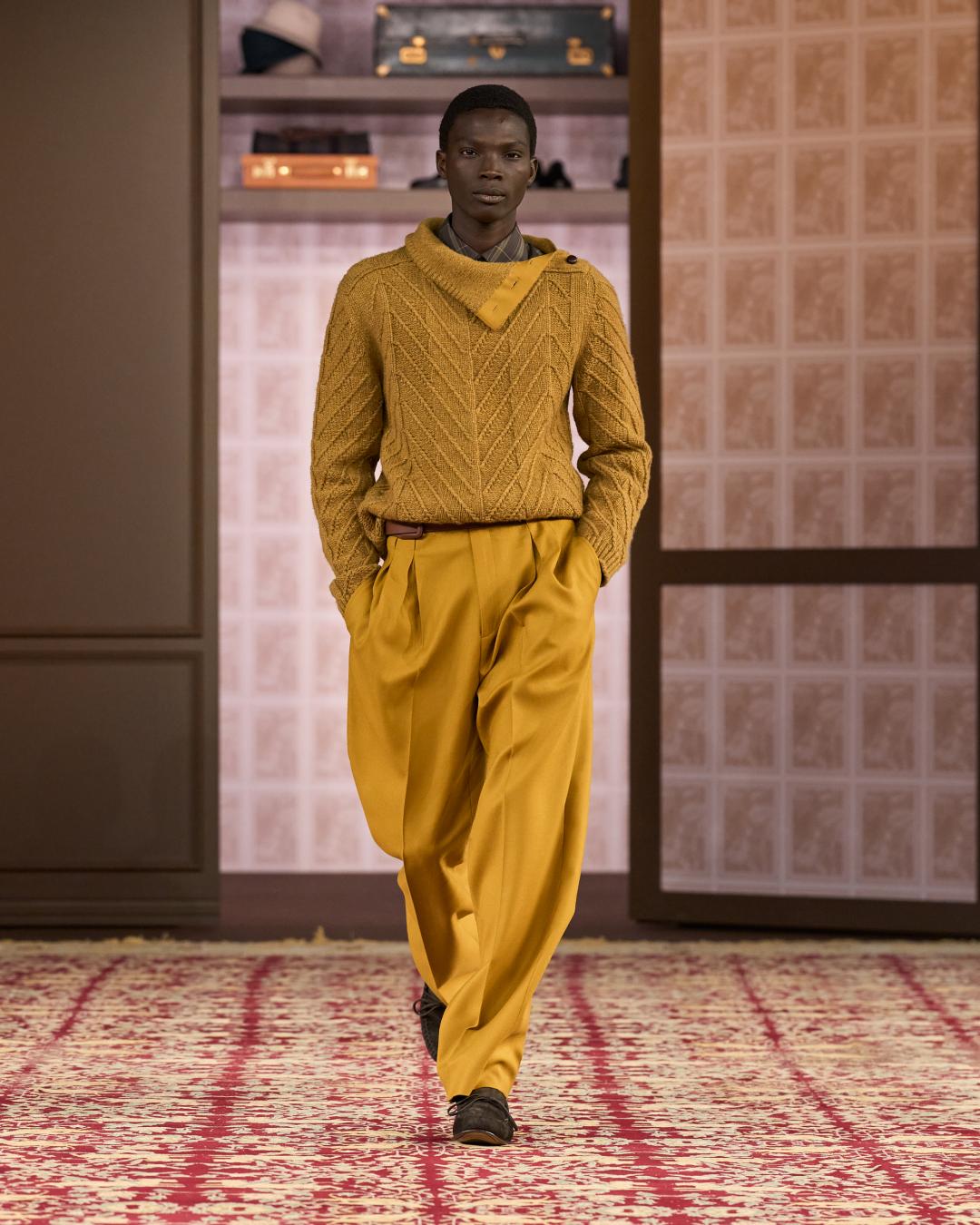 暖黃針織上衣搭配高腰長褲，色彩靈感汲取自然油畫，傳遞本季男裝重視穿著溫度的設計核心。