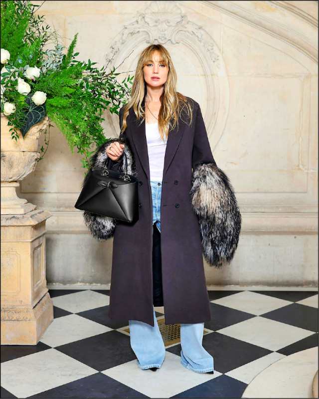 珍妮佛勞倫斯利用牛仔褲、白色棉質上衣搭配2026秋季系列絲質大衣，以個性感裝束現身看秀。