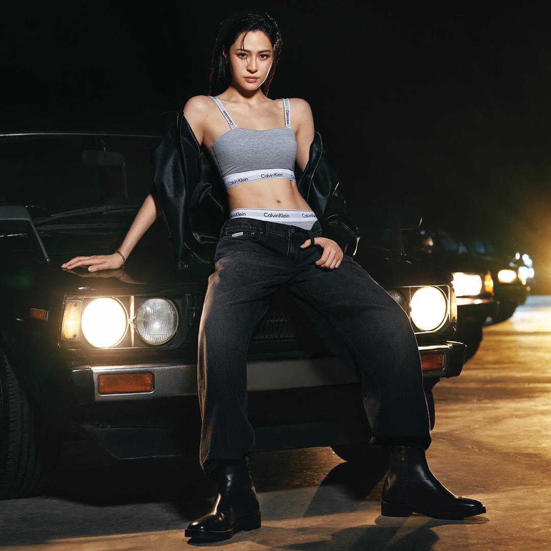 鄺玲玲以運動風內著搭配寬鬆牛仔褲，倚靠著老車呈現反骨態度。