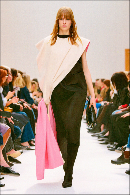 Celine以不對稱披肩式上衣搭配修身長裙，柔和粉色裝飾與黑色也形成鮮明對比。