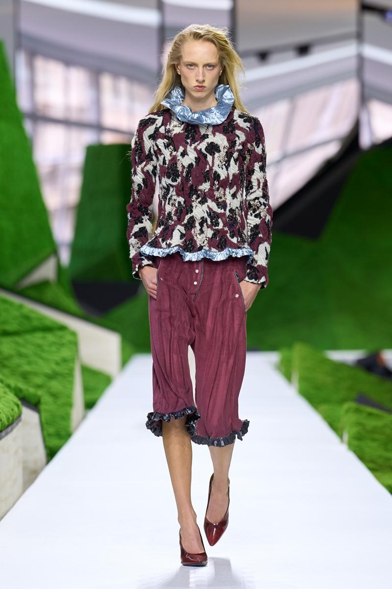 印花立體針織上衣搭配酒紅色七分褲，透過植物與動物意象圖紋，呼應系列以自然生態為靈感的主題。（Louis Vuitton提供）