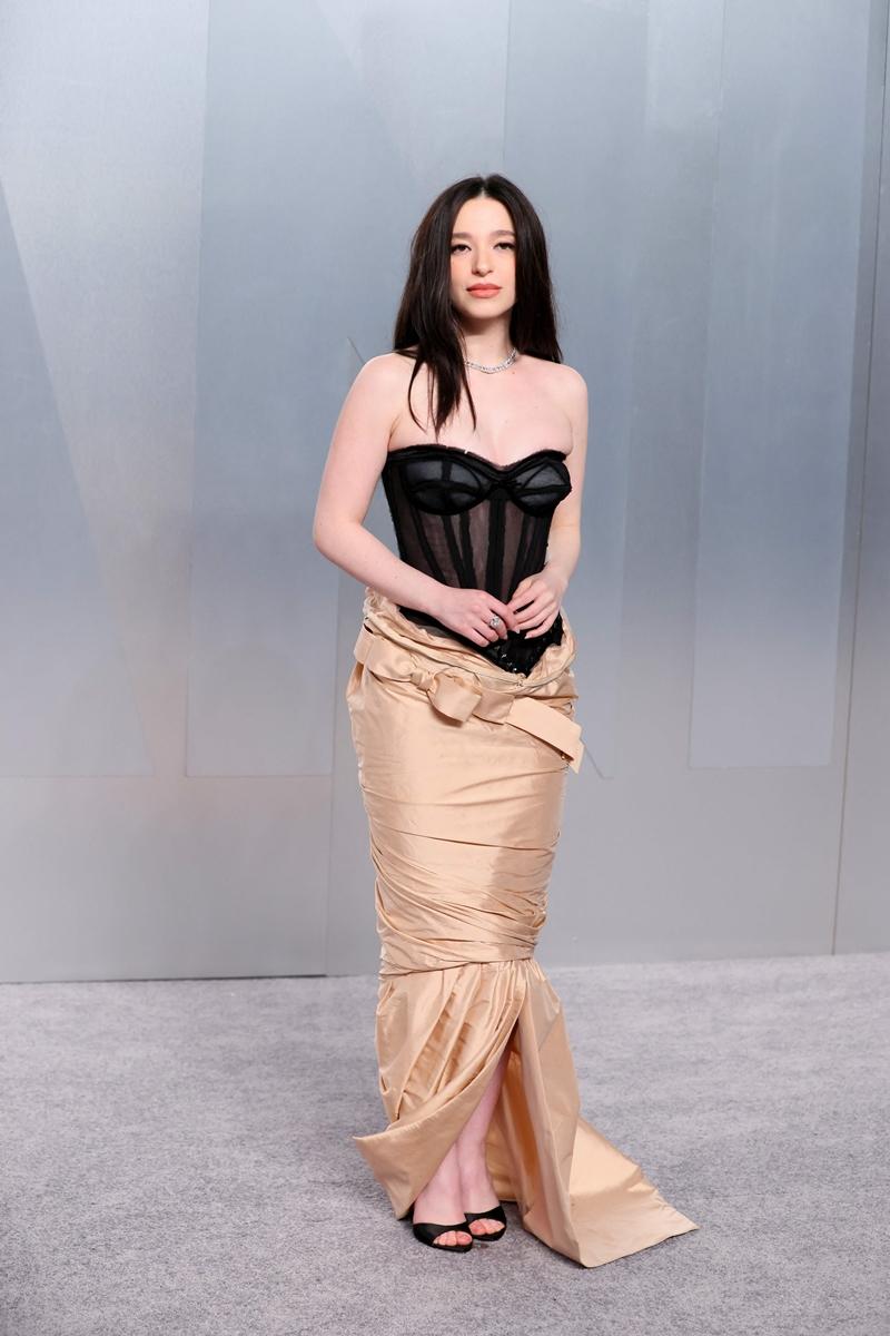 Mikey Madison身穿Dior黑色透視馬甲上衣搭配香檳色長裙的造型，呈現復古內衣外穿風格。