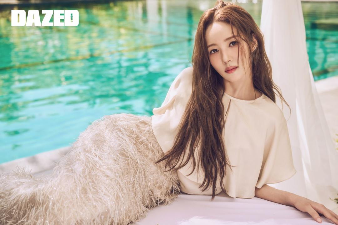 樸敏英側臥在蔚藍泳池旁，身穿羽毛裙裝展現優雅且高冷的時尚態度。（翻攝自instagram）