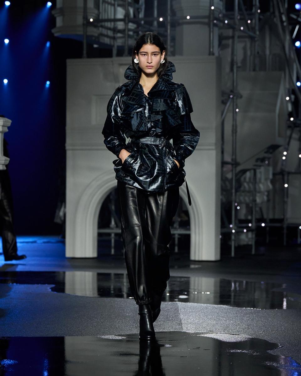 BURBERRY利用光澤皮革與荷葉細節重塑經典風衣結構，為傳統設計注入當代氛圍。