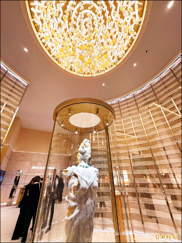 一走進寶格麗展區，即可見披戴珠寶作品的大理石雕像，天花板的水晶燈靈感來自羅馬陽光，連結品牌誕生地。（記者余崇慧攝）