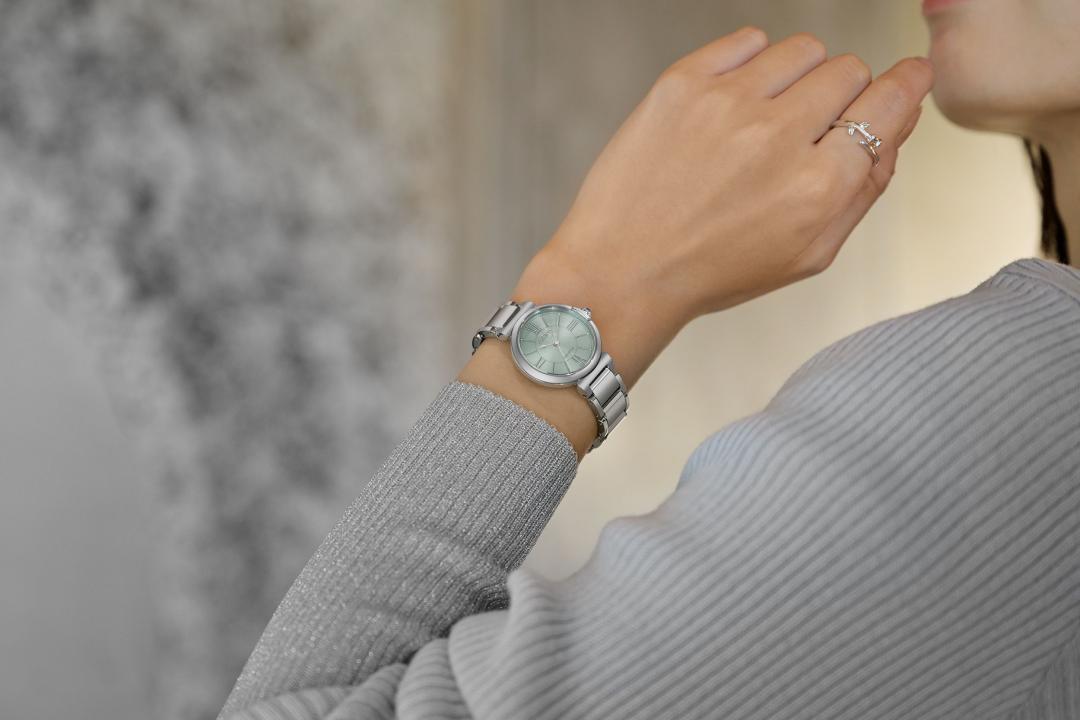 EM1070-83L錶款以綠波錶盤搭配纖細造型的羅馬數字時標，彷彿水滴滋潤大地。