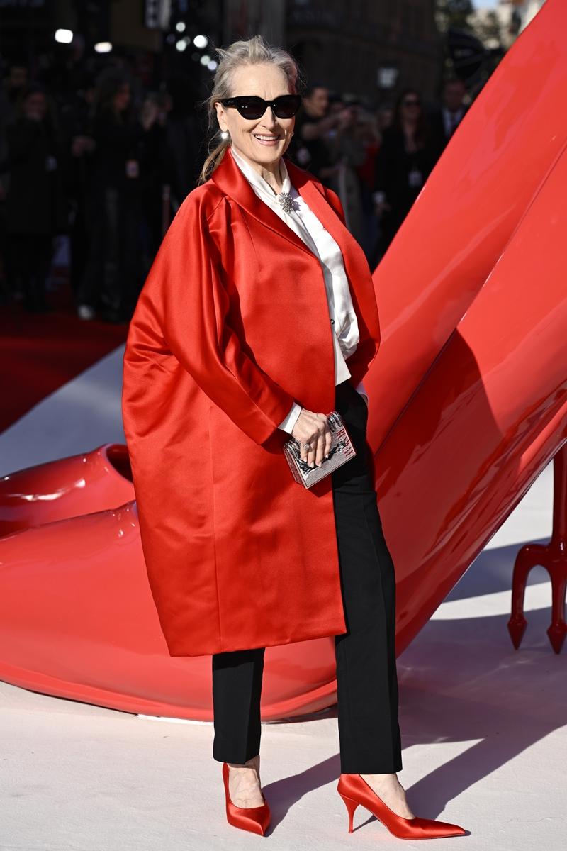 梅莉史翠普選穿Prada亮紅色緞面長版外套出席電影宣傳，內搭白襯衫與黑色長褲，搭配同色高跟鞋與墨鏡，展現經典又強勢的時尚風格。（Prada提供）