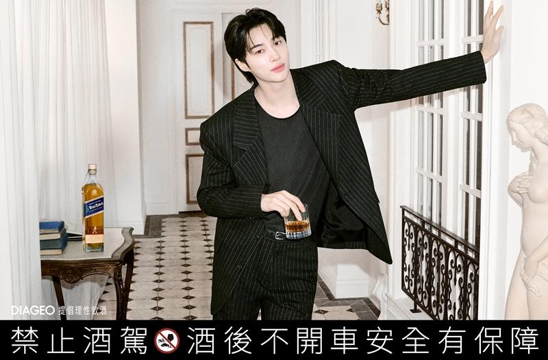 邊佑錫身穿黑色細條紋西裝拍攝形象照，手持酒杯展現沉穩氣場。（DIAGEO提供）