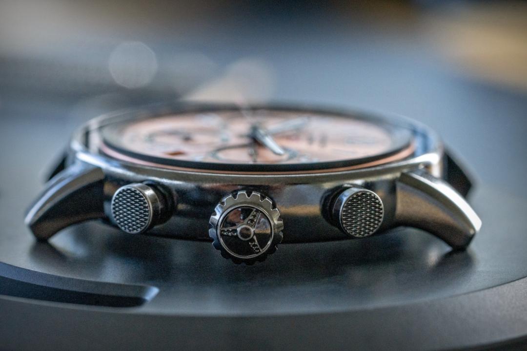 Mille Miglia Classic Chronograph Patina首次採用DLC鍍層Lucent Steel™精鋼錶殼，並透過特殊摩擦研磨工藝營造歷經歲月洗禮的磨耗質感，錶冠飾有方向盤圖案，細節呼應賽車文化。（Chopard提供）