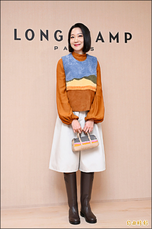 曲家瑞選擇Longchamp×Caroline Hélain膠囊系列背心（59,100元），搭配摩卡色平底靴（26,800元）展現率性魅力。（記者胡舜翔攝）