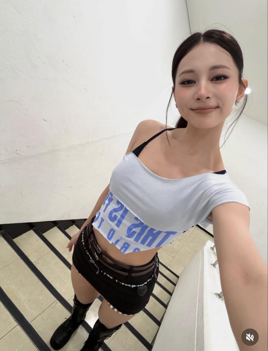 白色不對稱短版上衣搭配黑色迷你裙，周子瑜對鏡自拍與粉絲分享後台造型。（翻攝自instagram）
