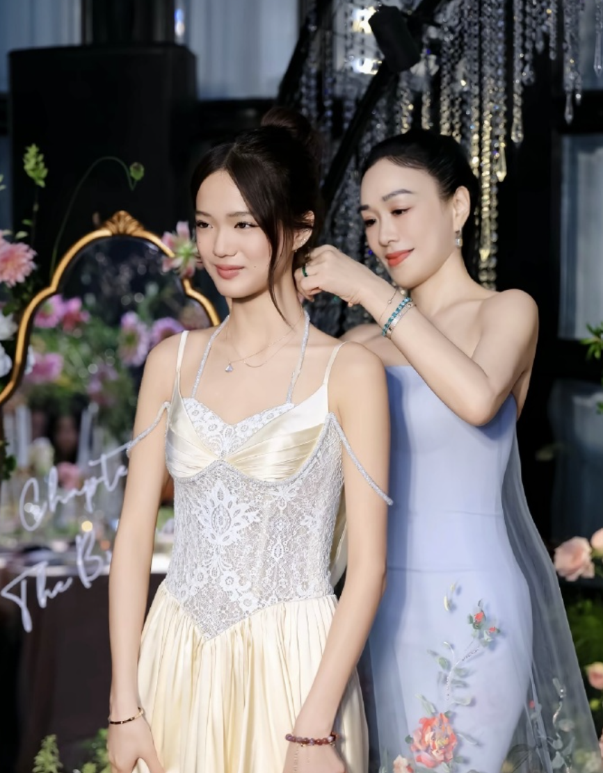 鍾麗緹為寶貝女兒戴上寶格麗項鍊。