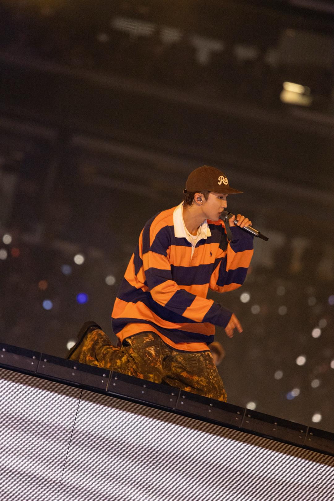 RM以橘藍配色橫條紋Polo衫登台，展現Polo Ralph Lauren代表性的學院風格。
