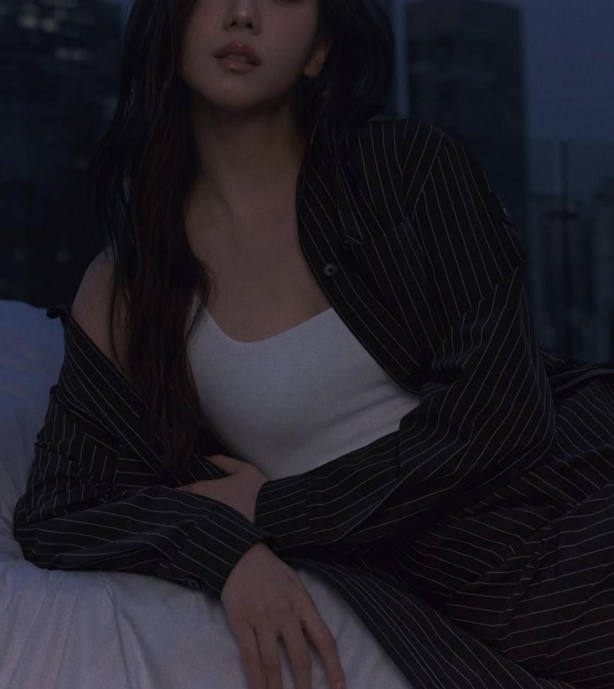 Jisoo以白色背心搭配黑色條紋套裝，昏暗光影襯托沉靜神情。（翻攝自instagram）