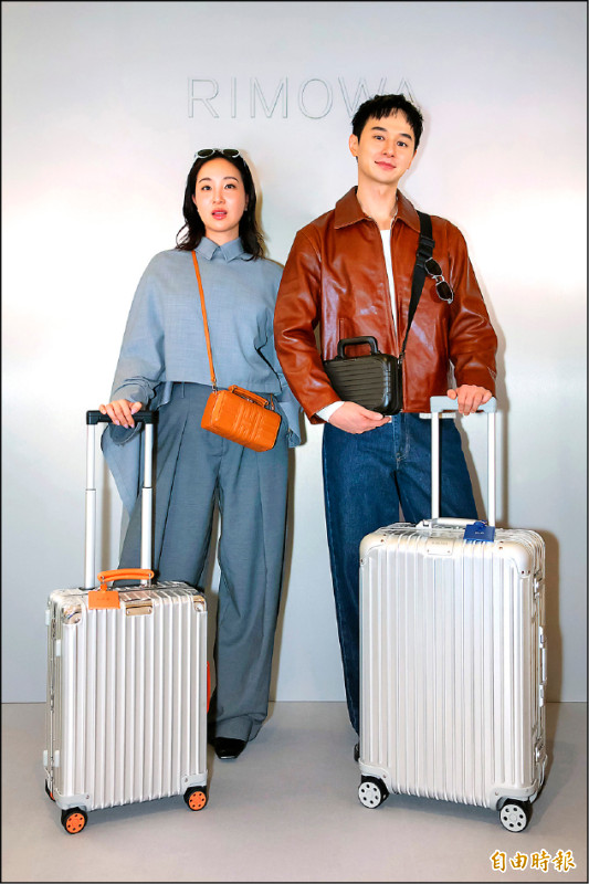 張軒睿（圖右）攜帶RIMOWA Original系列Check-In M銀色行李箱（69×44×27.5cm，61,300元），Melinda（圖左）則選擇Classic系列Cabin銀色行李箱（55×40×23cm，56,000元）登場，詮釋摩登的旅行風格。（記者張妤瑄攝）