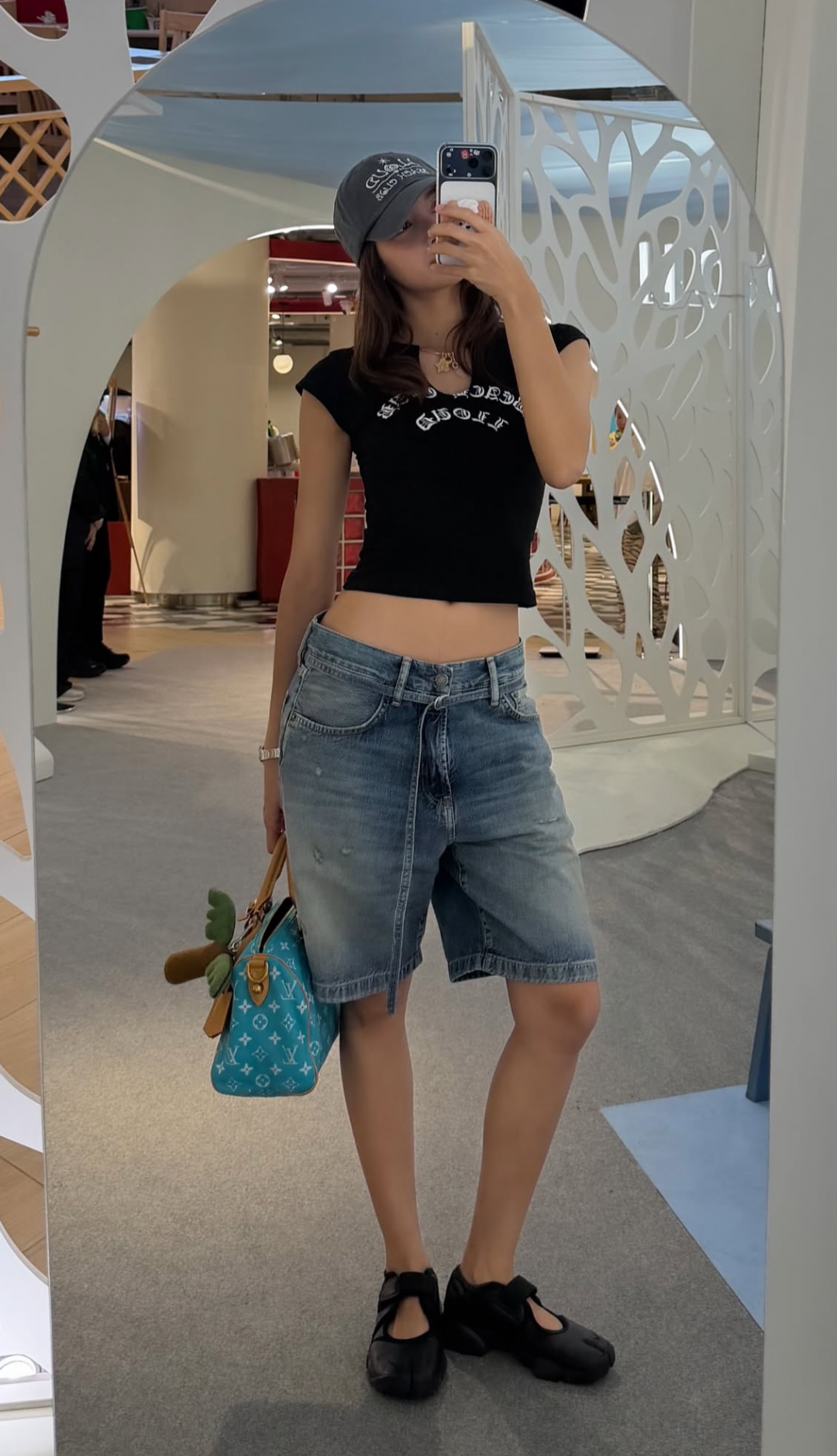 Lisa以黑色短版上衣露出纖腰，手提LV藍綠色包款，為休閒造型注入鮮活魅力。（翻攝IG＠lalalalisa_m）