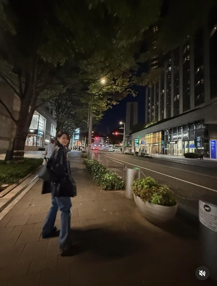 孫藝真走在韓國夜晚街頭，不時回頭對鏡頭露出笑容，動態感十足的畫面更顯自然。（翻攝自instagram）