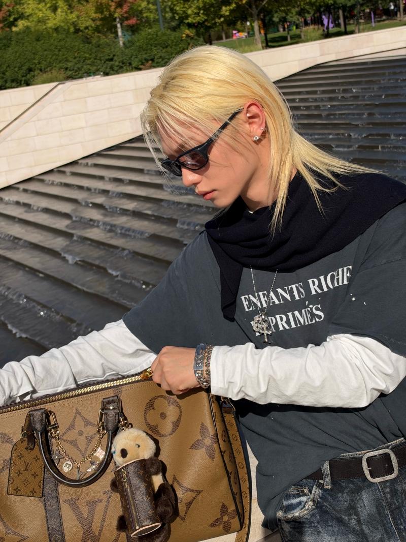 Felix的金髮搭配窄框墨鏡展現鮮明個性，手邊Keepall Monogram Giant旅行袋掛滿玩偶與吊飾，成為視覺焦點。（Louis Vuitton提供）