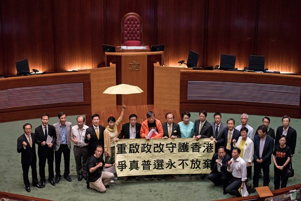 香港立法會十八日以廿八票對八票，正式否決政改方案，表決結果出爐後，成功封殺議案的泛民派議員在議場中央拉起布條、高舉黃傘，高呼「重啟政改」、「爭真普選永不放棄」等口號。（法新社資料照）