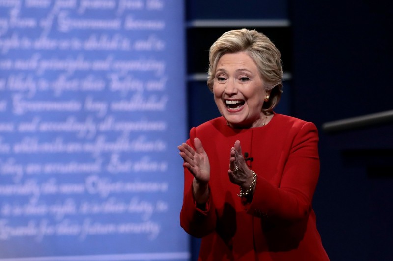 從希拉蕊選擇大紅色的服裝不難看出，她刻意藉由外型的紅潤呈現精神飽滿，來對比日前她參加九一一紀念活動時，肺炎發作被人攙扶上車的疲憊模樣。（AFP）