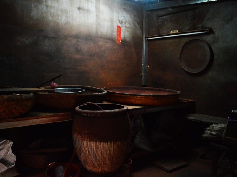 製香房內陳設，三個裝香粉的大米篩、浸水的大缸、還有一些木架。/圖片來源：顏麗家攝