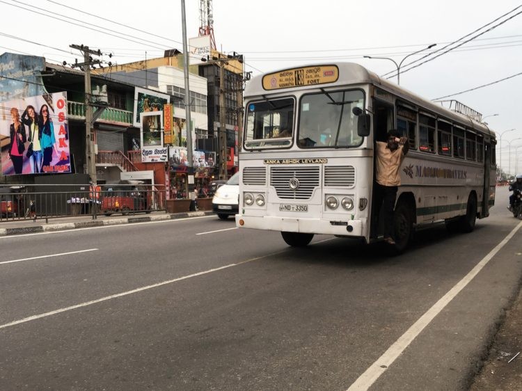 民營的白色公車，收錢攬客的小哥通常會站在車門處。