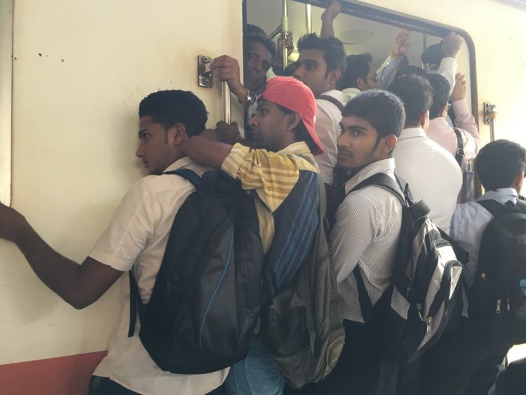 乘客如同沙丁魚般的擠入和攀附在火車車廂。