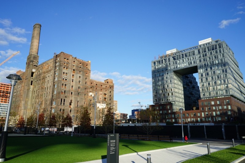 Two Trees Management的Domino糖廠開發案第一件完成使用的住宅建築325 Kent Avenue和旁邊Domino Sugar Refinery 150年的建築形成鮮明對比。（圖：作者提供）