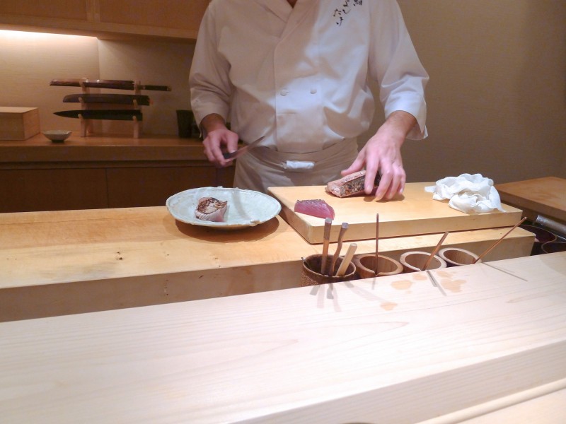 吉武是東京和食店，連續13年都是米其林三星，看他手上與身後的刀具，都是非常講究。（作者提供）