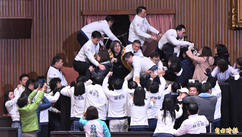 國民黨展開強烈攻勢，企圖排除障礙攻上主席台。（記者劉信德攝）