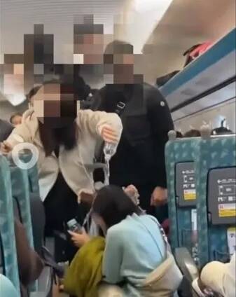 高鐵爭座爆發衝突，憤怒的媽媽拿礦泉水淋在藍衣女子頭上。（翻攝自爆廢公社）