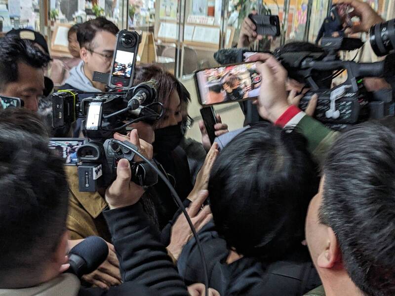 北院裁定柯文哲3千萬元交保，立委黃國昌妻子（黑口罩者）到法院辦理交保。（中央社）