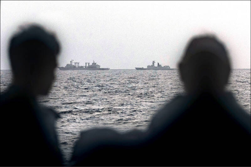 澳洲國防軍日前拍攝與發布的照片顯示，澳洲海軍士兵在軍艦上遠眺於紐澳之間塔斯曼海進行實彈軍演的中國人民解放軍補給艦「微山湖艦」與護衛艦「衡陽艦」。（法新社檔案照）