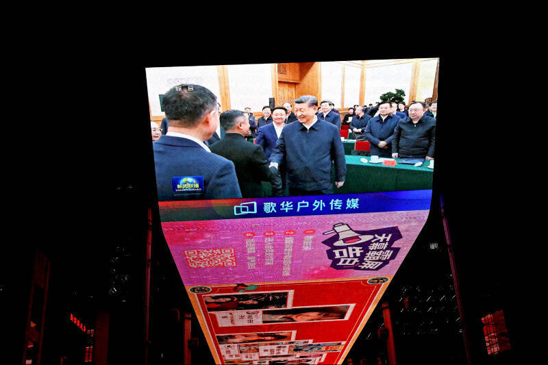 北京一家購物中心螢幕，播放民營企業家座談會中，中國國家主席習近平與阿里巴巴創辦人馬雲握手的新聞。（路透）