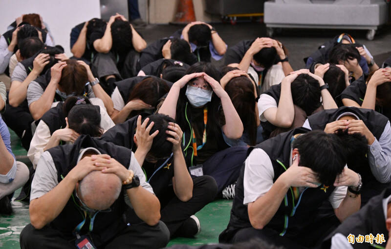 北部地區城鎮韌性演習7月17日登場，桃園機場公司員工疏散至地下室，以手抱頭演練避難流程。（記者劉信德攝）
