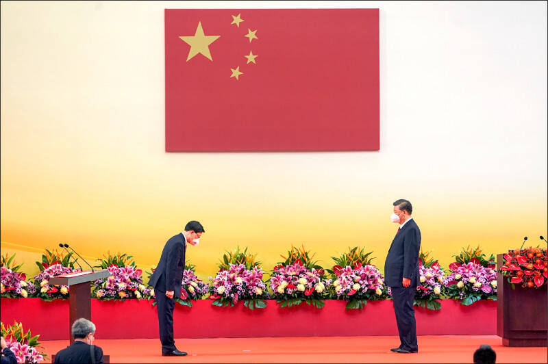 香港是美中兩強短兵相接之地，習近平掌權之後的再極權化與安全化波及香港。圖為香港特首李家超（左）就職時，向中國國家主席習近平鞠躬。（歐新社檔案照）