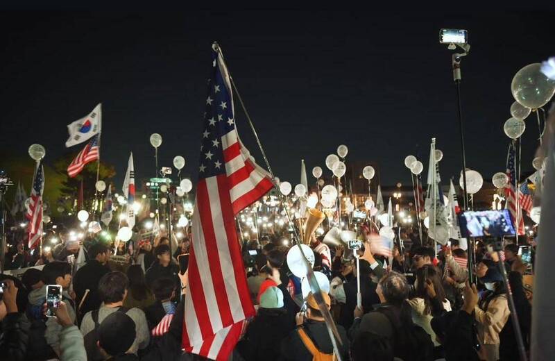 民眾手持韓、美國旗，呼籲美國強化韓美同盟以制衡中國。（作者提供）