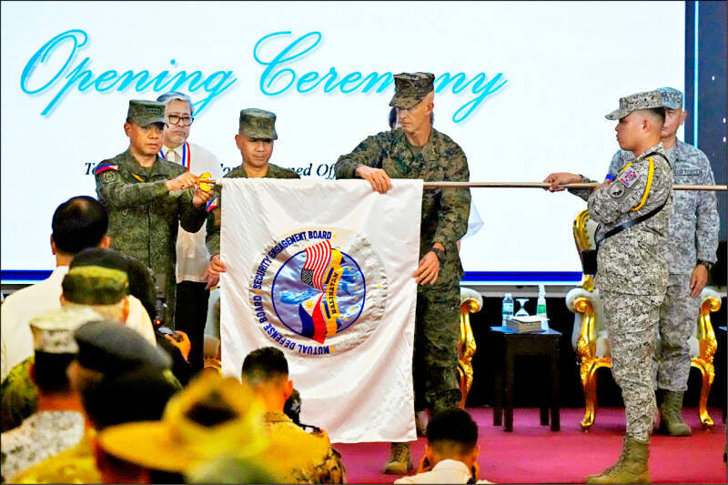 美菲於4月間啟動「肩並肩」聯合軍演。圖為菲律賓參謀總長布勞納（左）與美方指揮官葛林中將（中）共同展開演習旗幟。（美聯社檔案照）