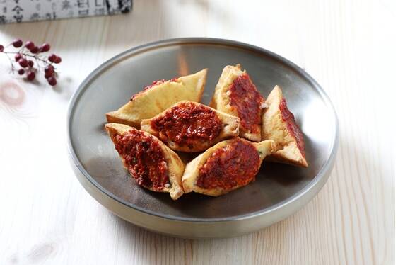 豆腐飯的做法是將豆腐切片後撒些鹽稍作醃漬，再用油煎得金黃香脆，然後將其剖開，夾入飯。（作者提供）