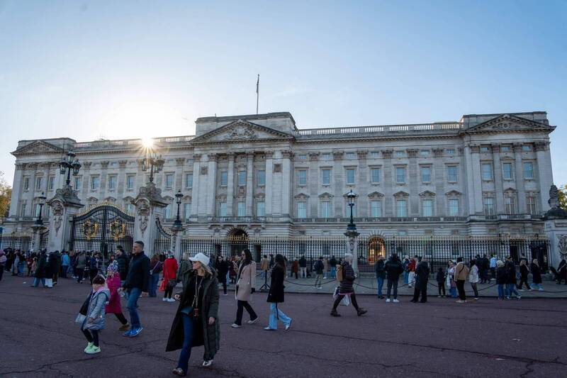 網路上瘋傳倫敦白金漢宮有「前所未有的皇家耶誕體驗」，遊客興沖沖地趕往，卻只見到冰冷的鐵欄杆與廣場。圖為白金漢宮外的遊客。（法新社檔案照）